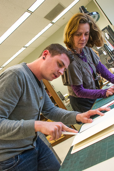 Conservator teaches student to repair books