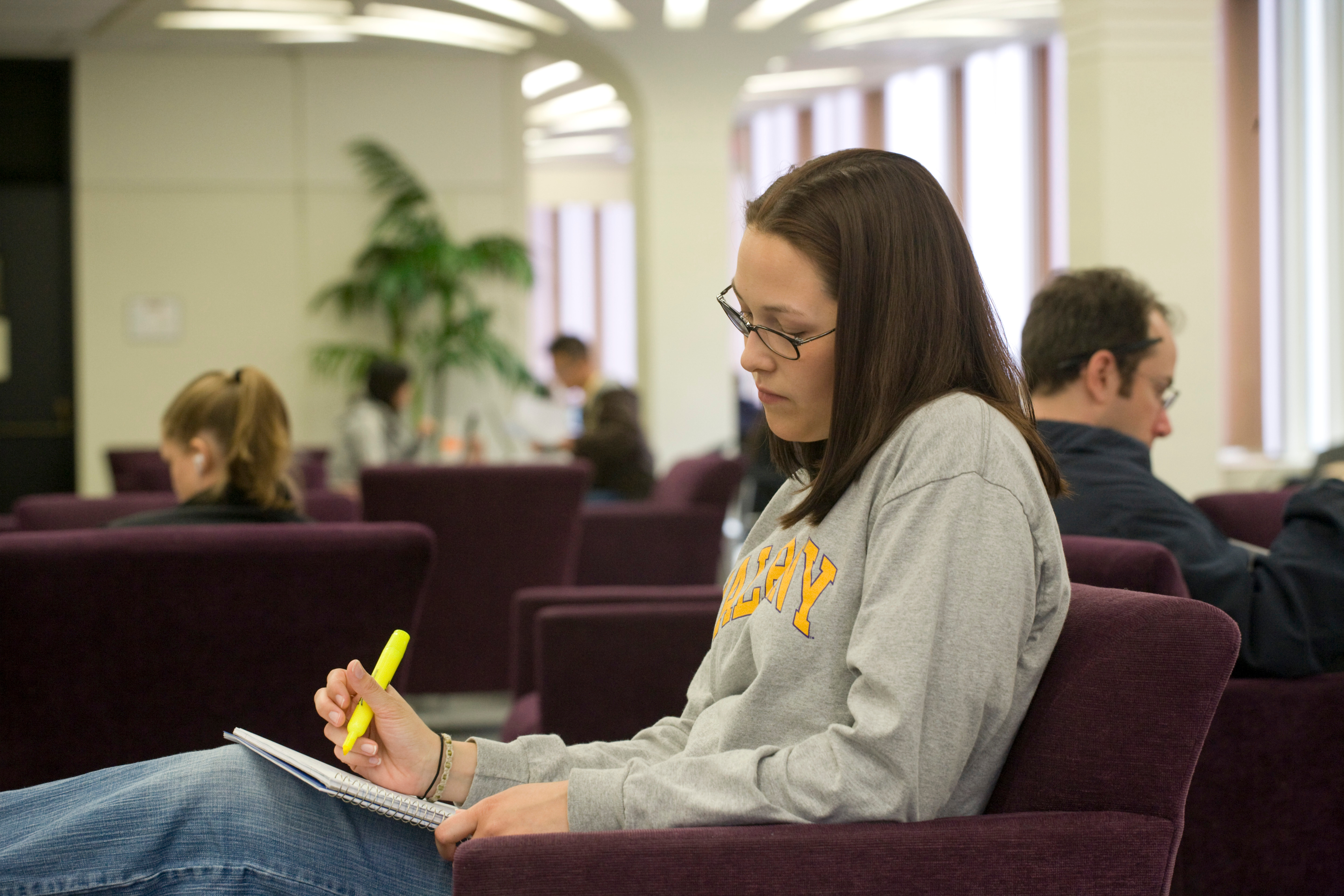 student in library highlighting notes