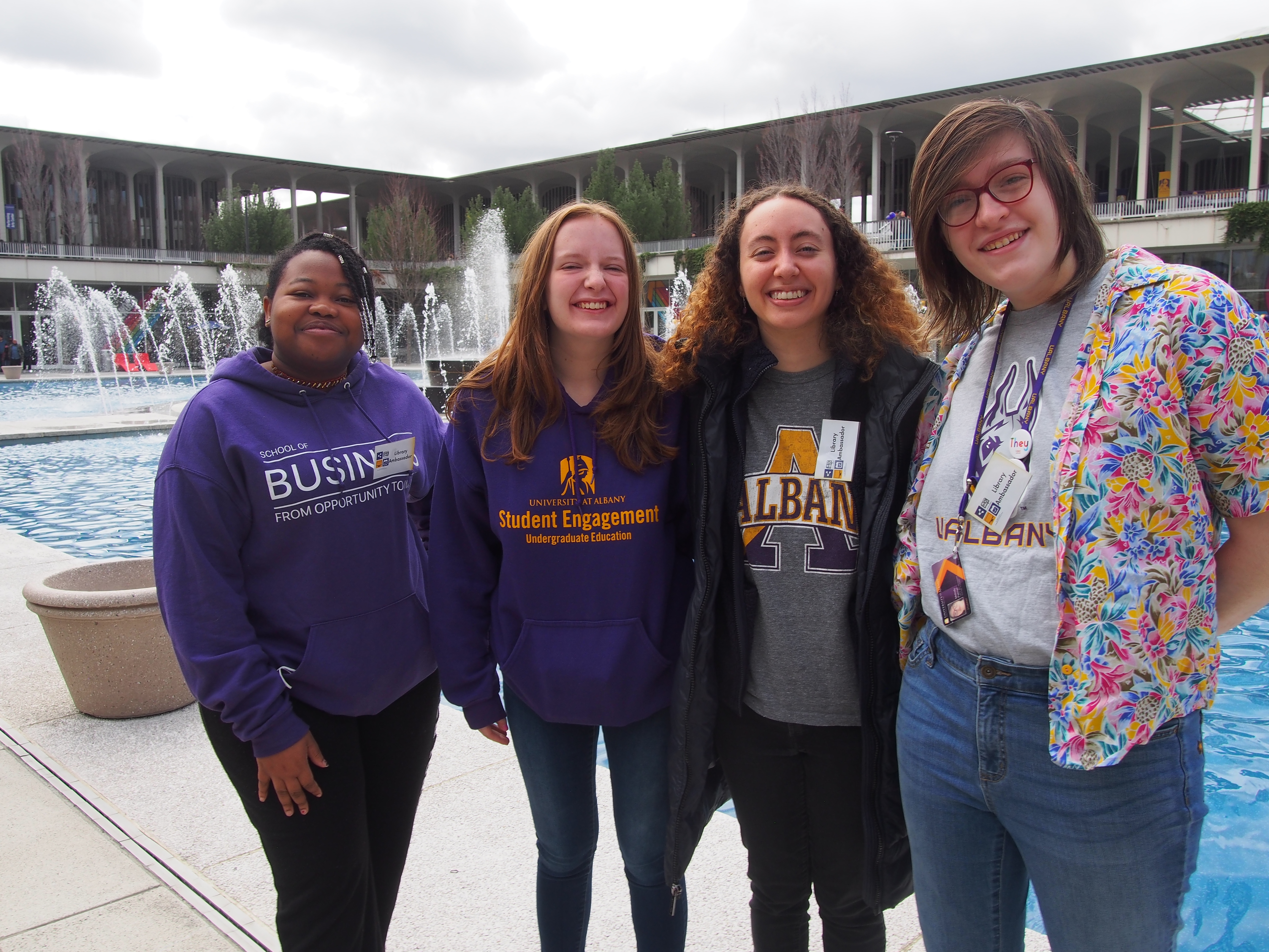 Four Library Ambassadors standing in front of the UAlbany fountain