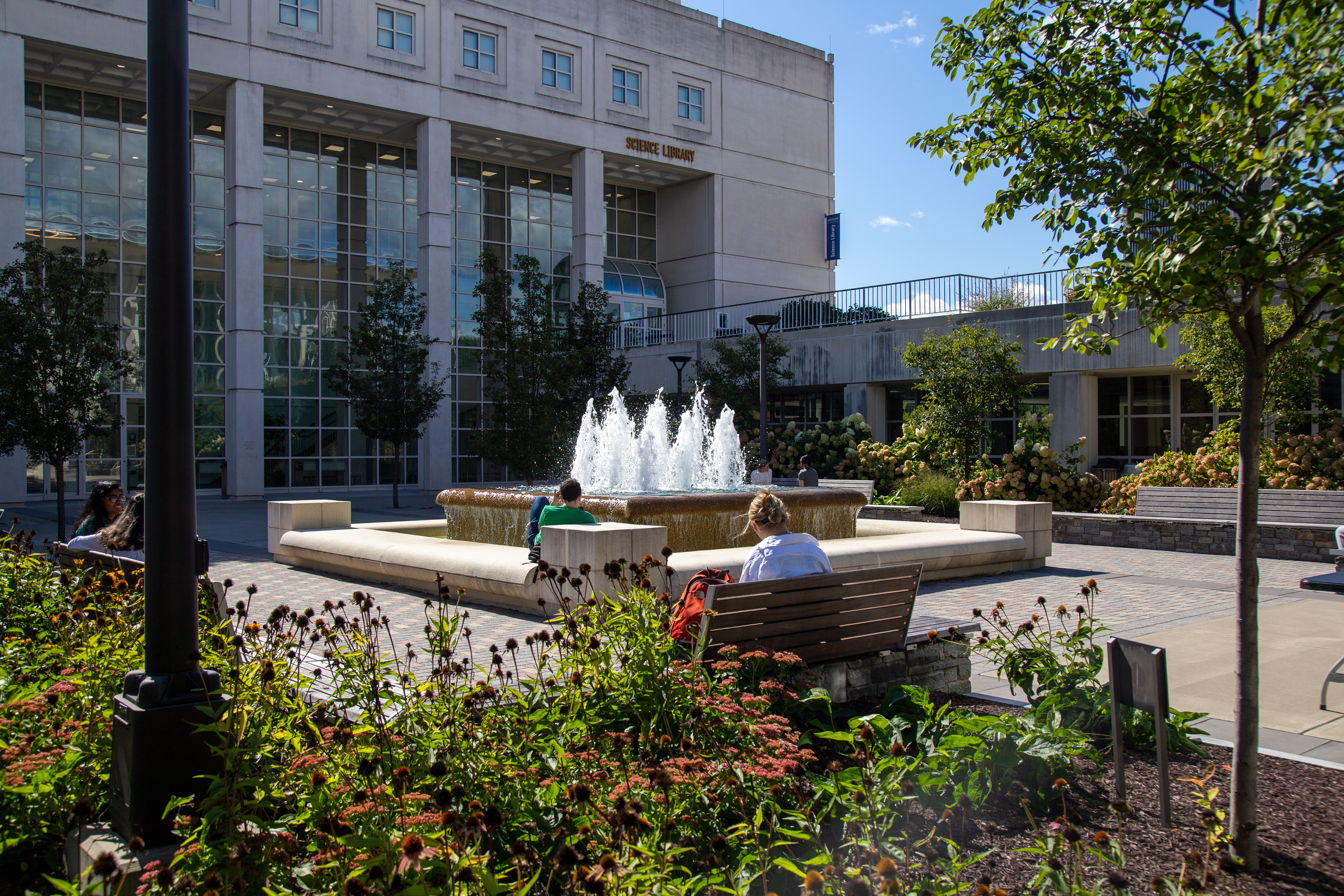 Students sitting outside of the Science Library, near the Parents' Fountain