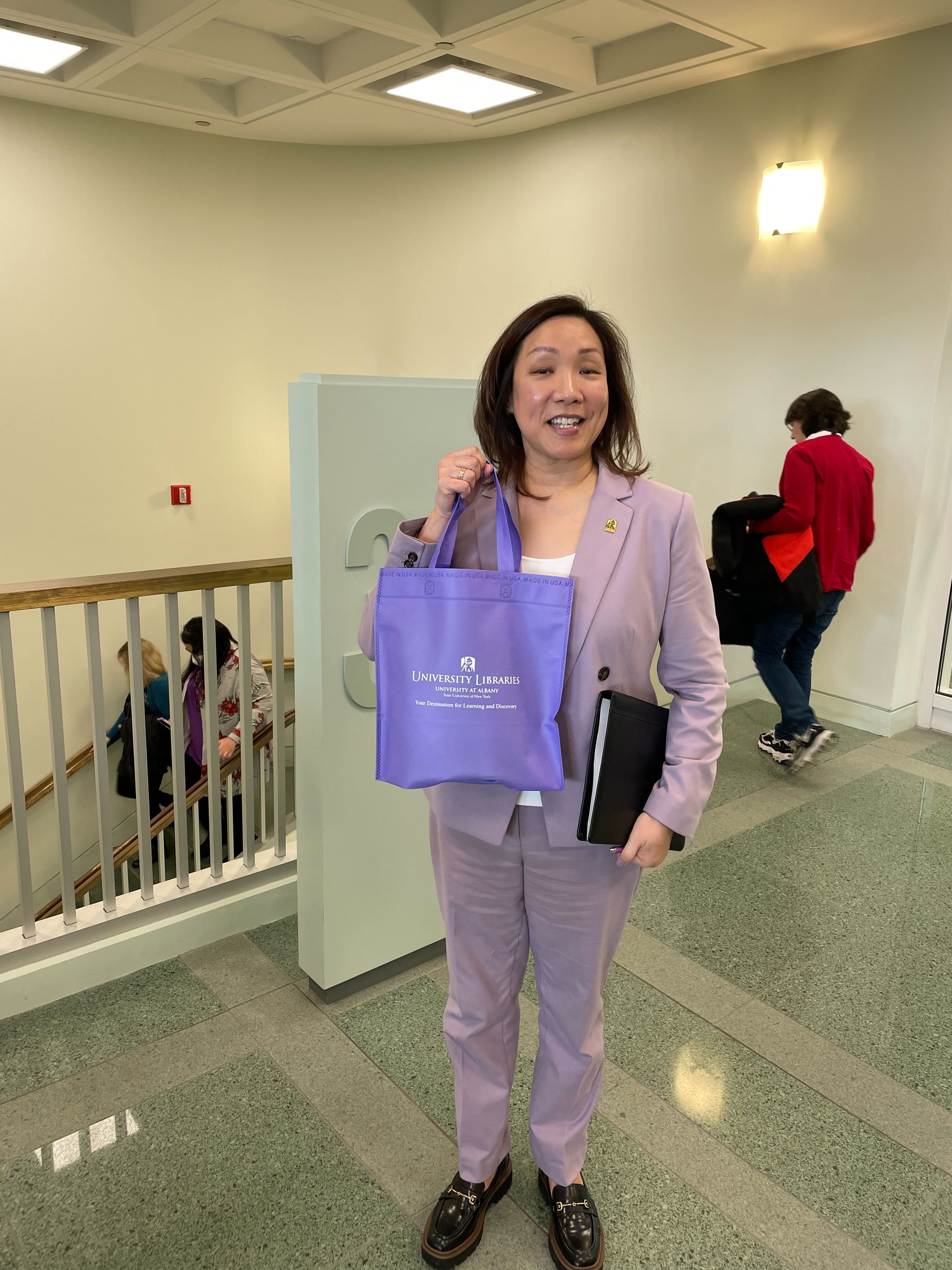 Provost Kim poses with a University Libraries tote bag