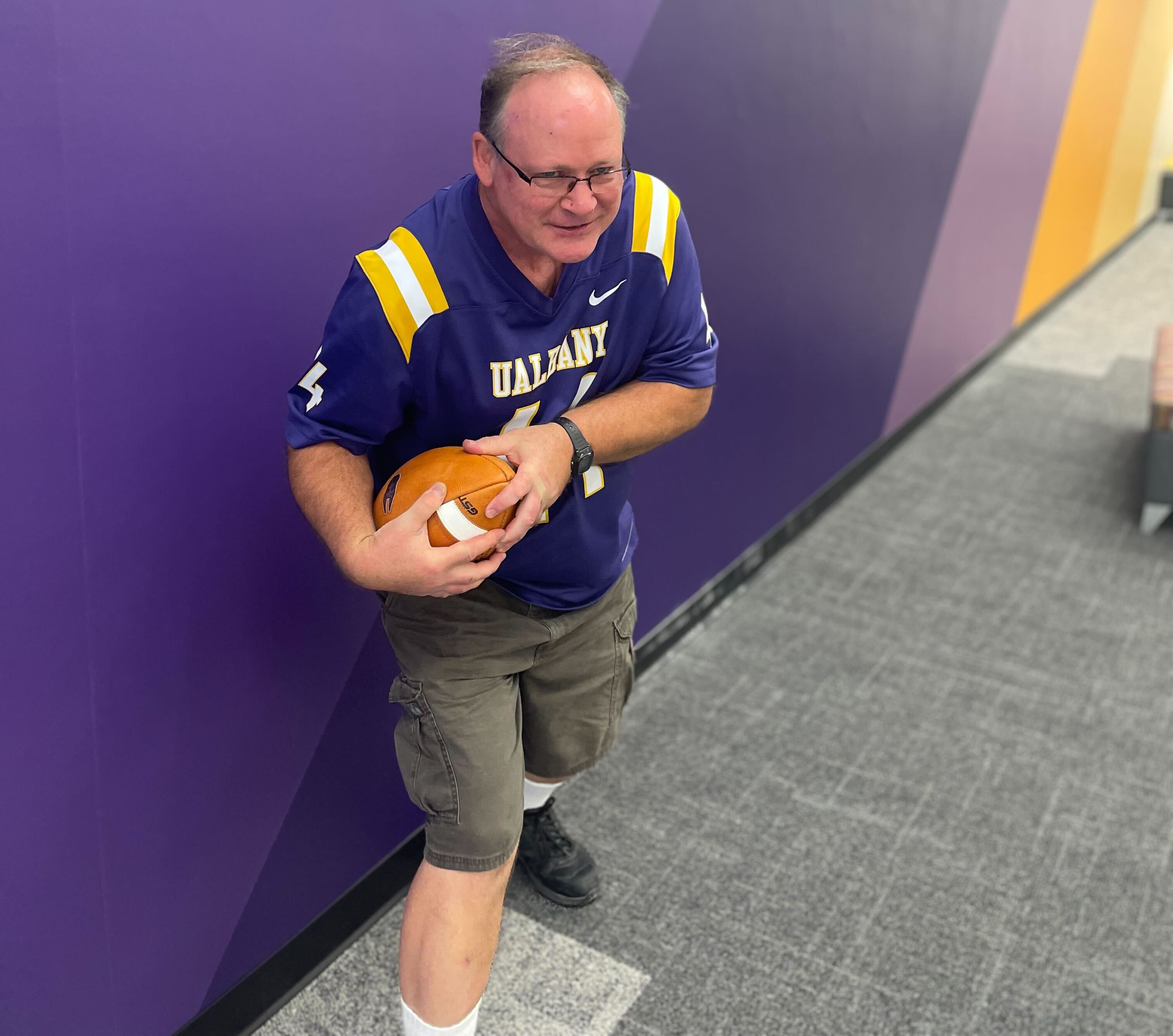 Brian King holding a UAlbany football