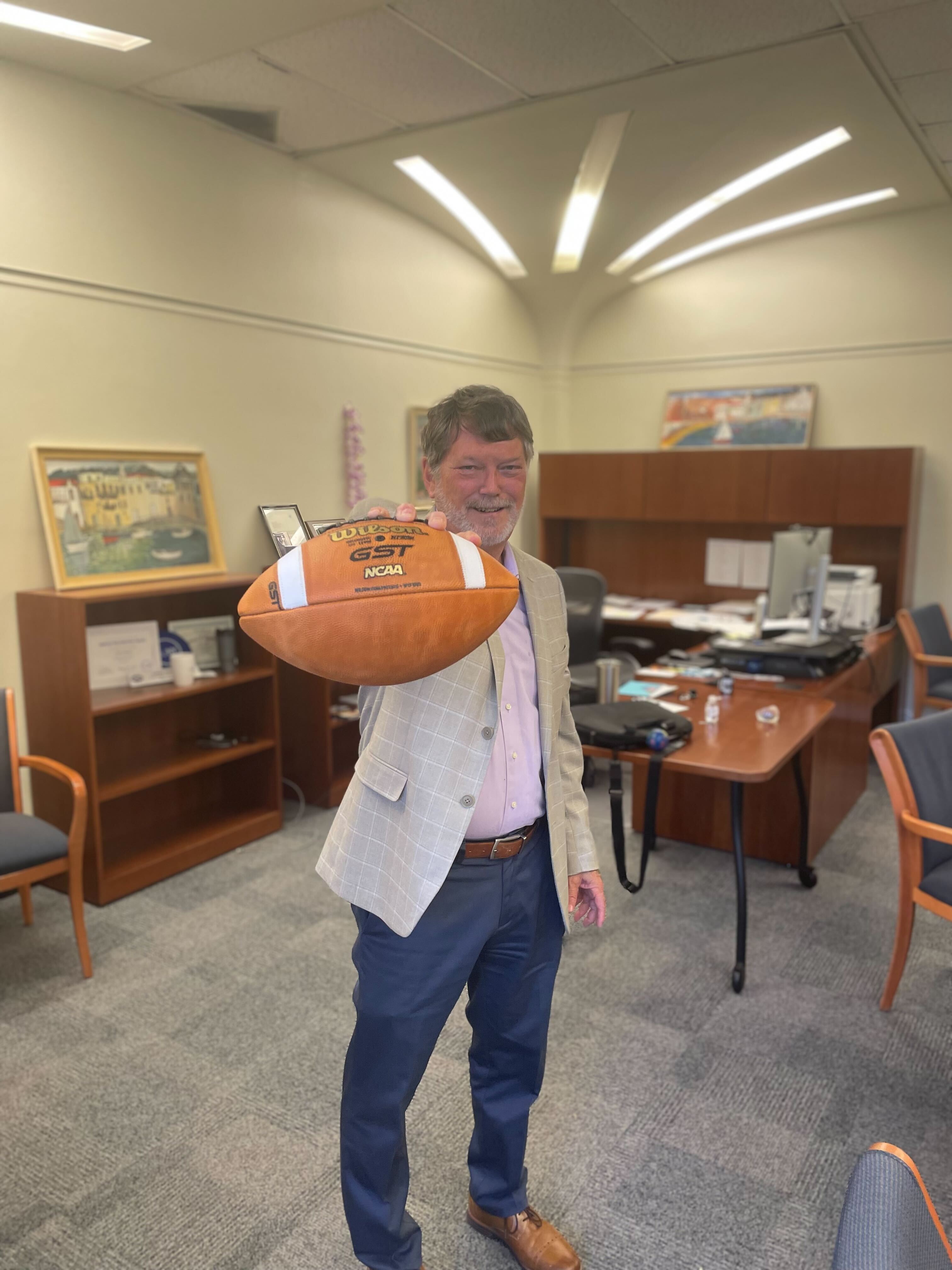 Carey Hatch in his office with a football