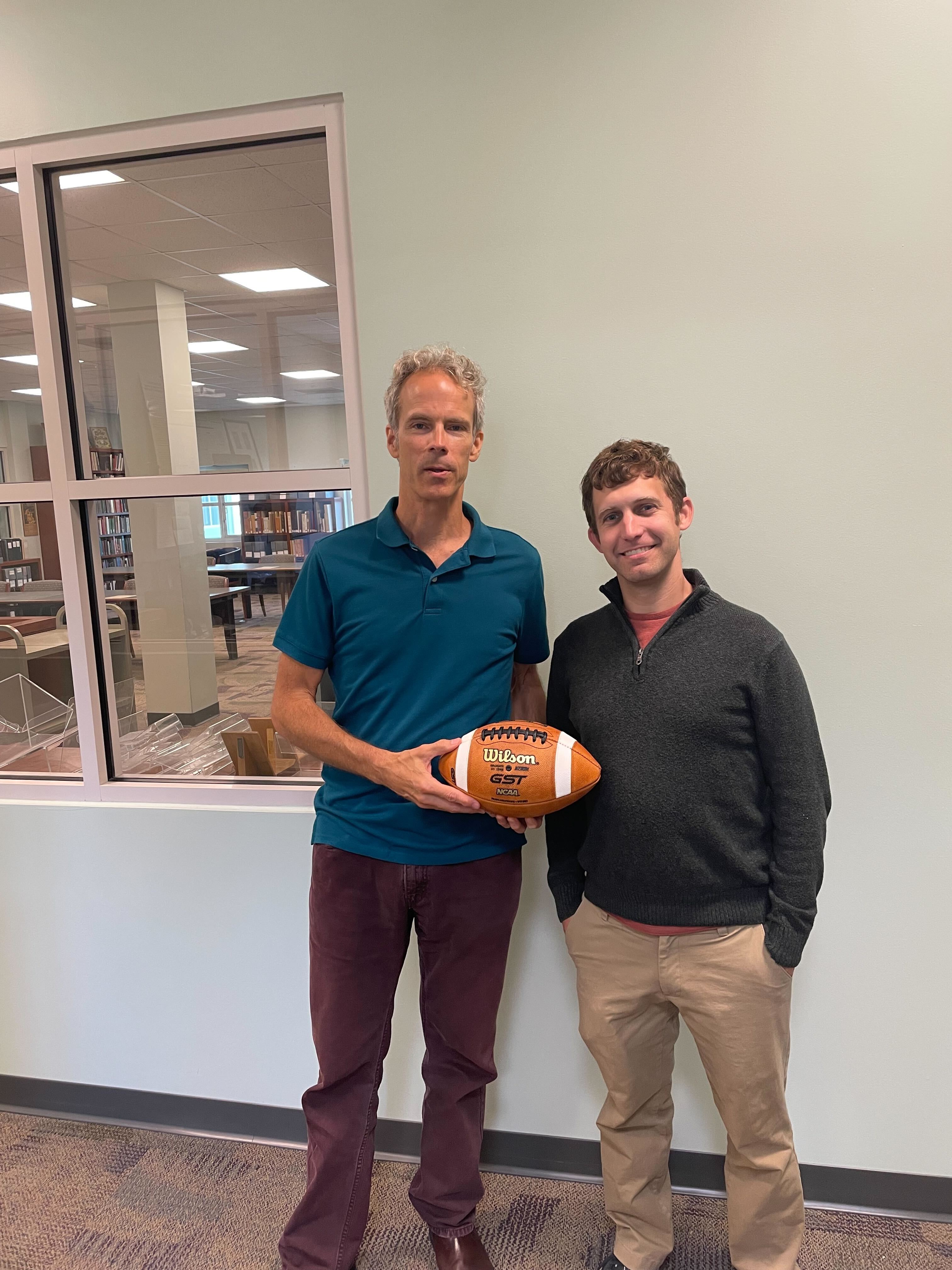 Mark Wolfe (left) and Greg Wiedeman (right) holding a football