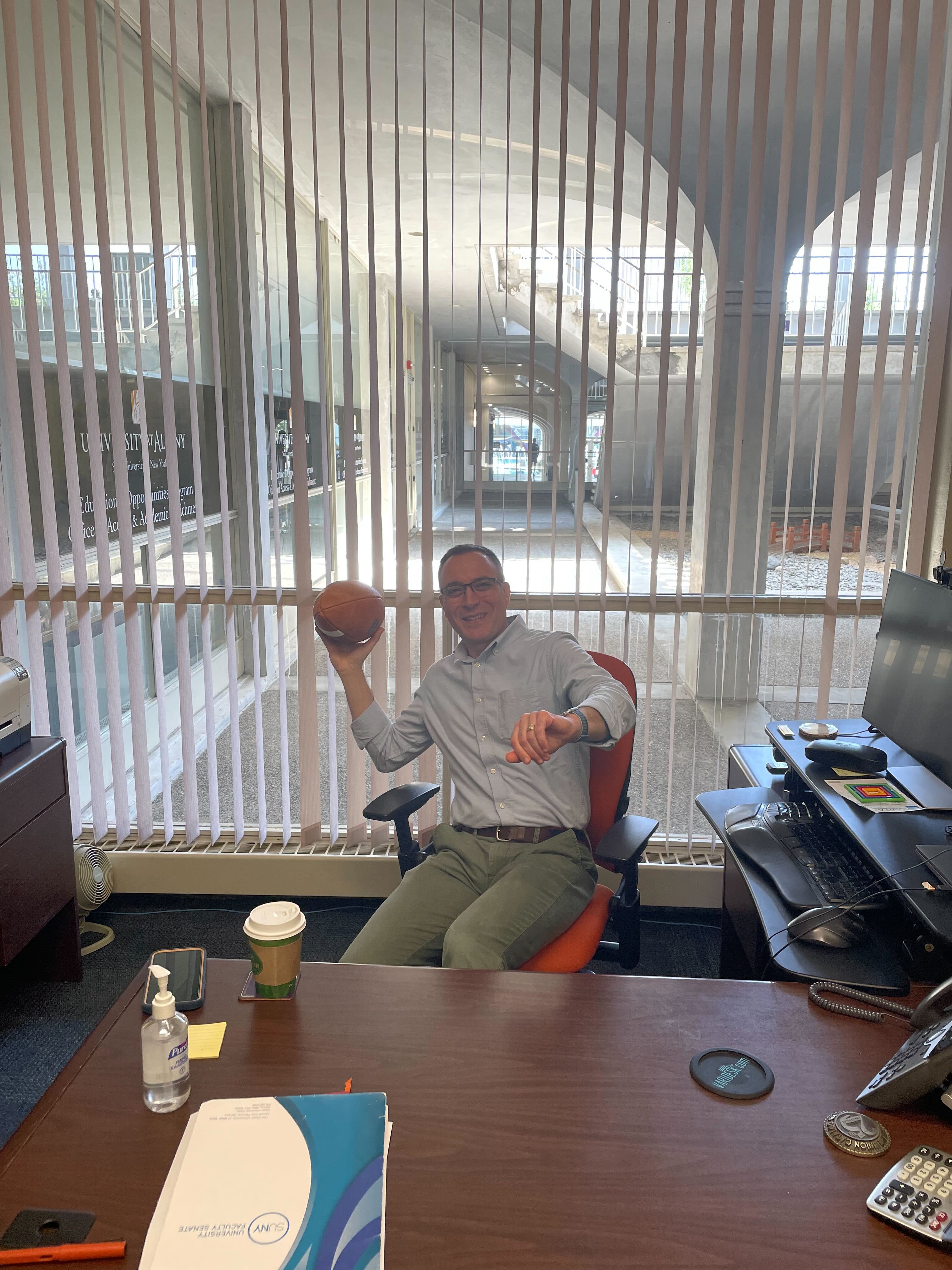 Kabel Stanwicks poses at his desk with a football