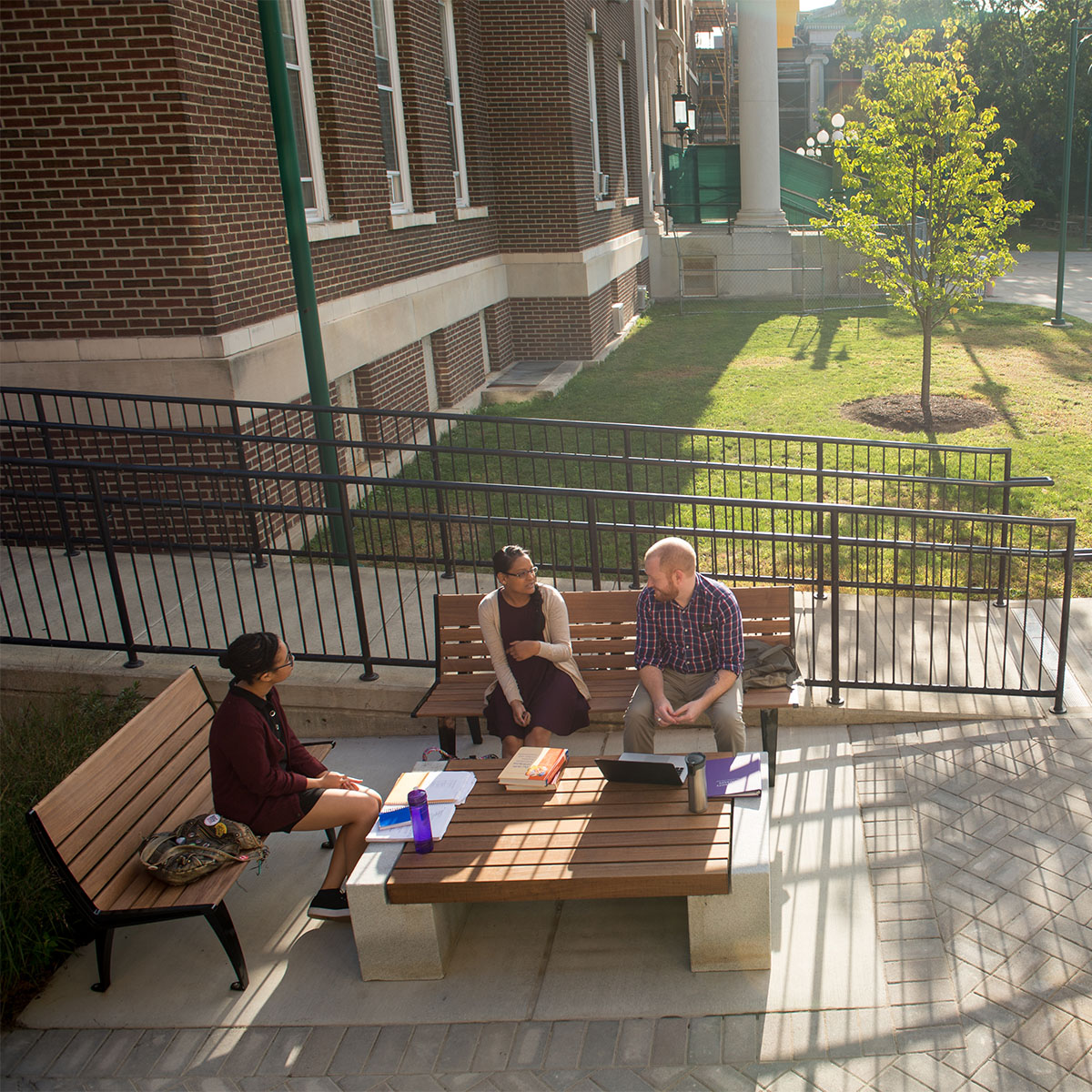 Students enjoy a chat on benches outside the Dewey Library