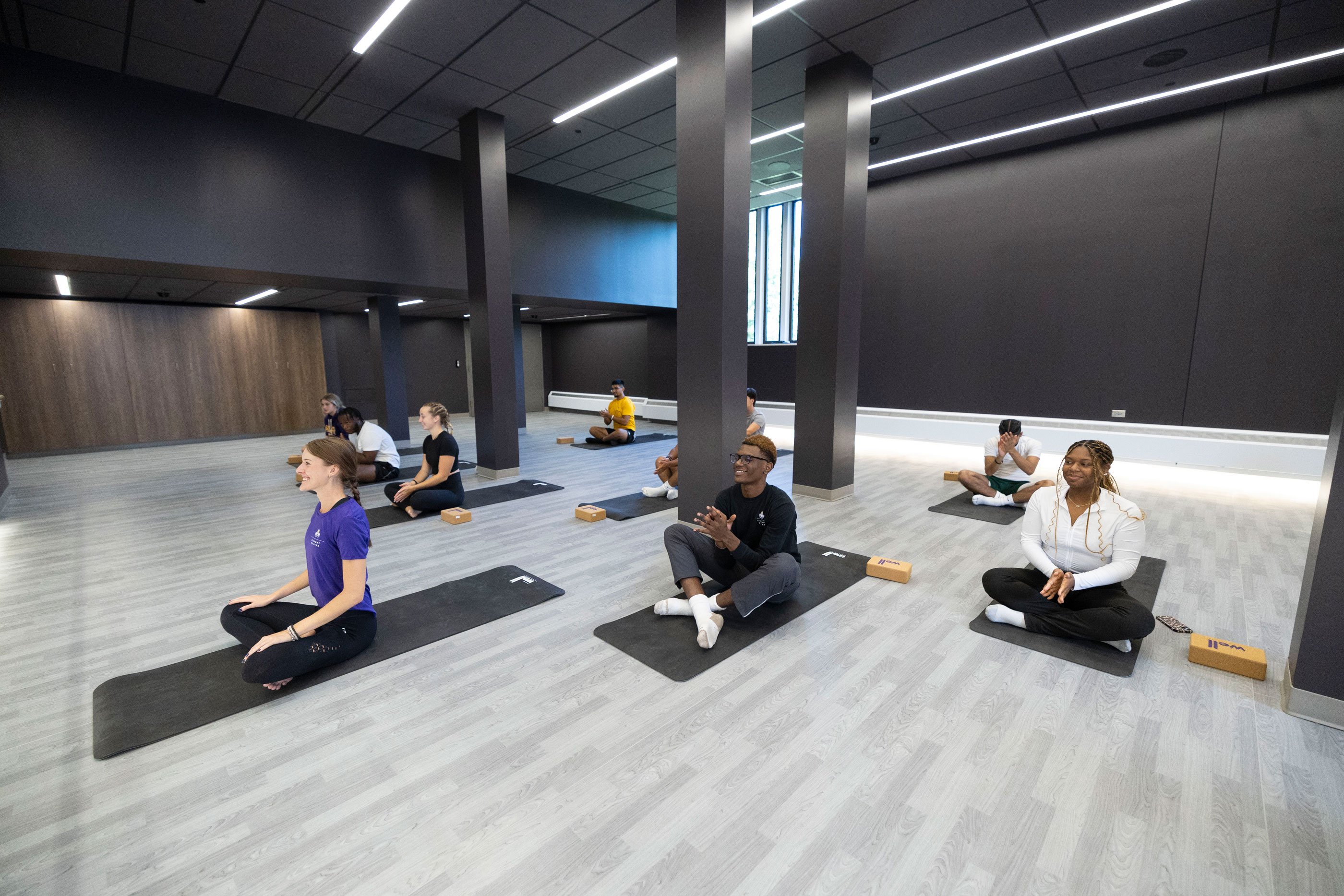 A group of students practicing yoga on floor mats.