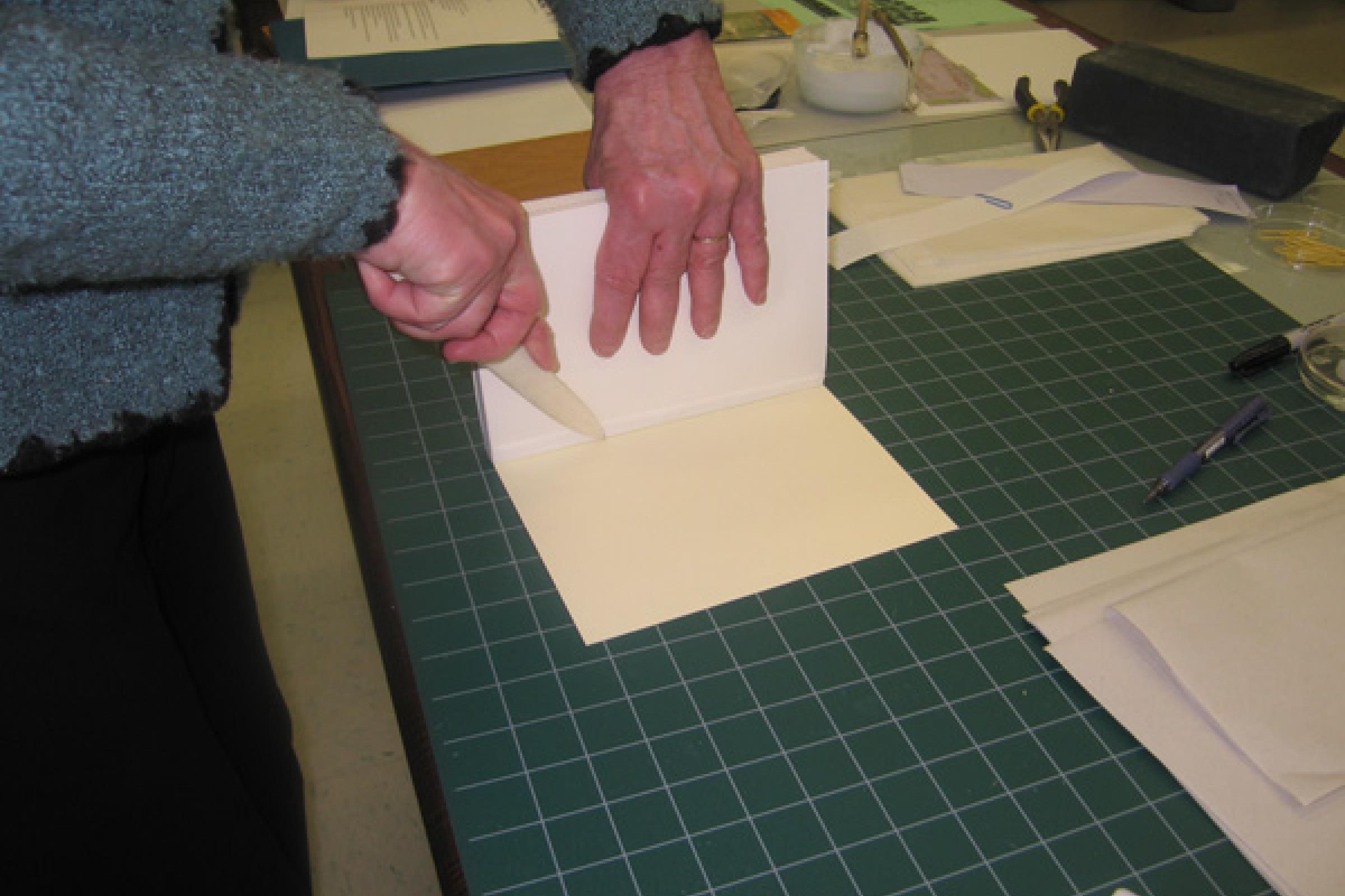 After glueing the strip to the board with PVA, the attachment is further reinforced by applying pressure with a bone folder