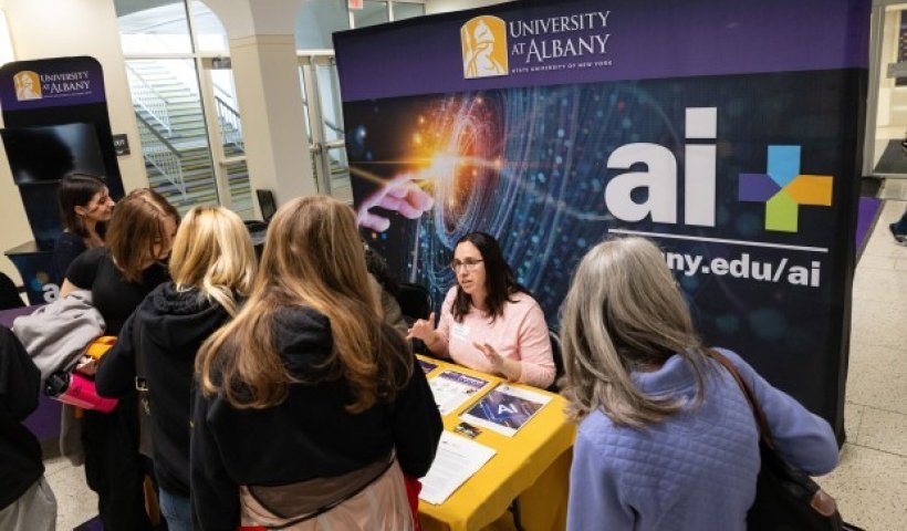 Students gathering around the AI Plus table at Showcase