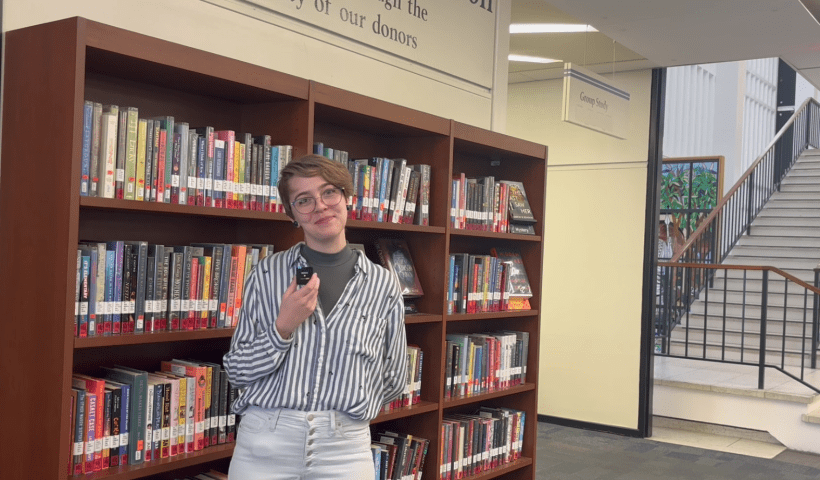 Clancey Staldine standing in front of the Popular Books collection