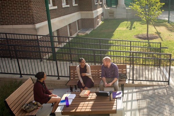 Students enjoy a chat on benches outside the Dewey Library