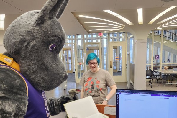 Damien the Great Dane checking out a book to a student