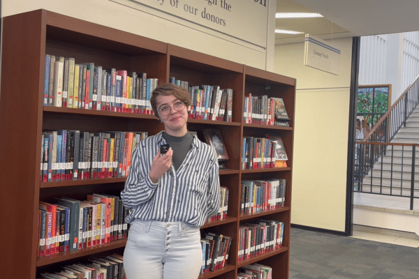 Clancey Staldine standing in front of the Popular Books collection