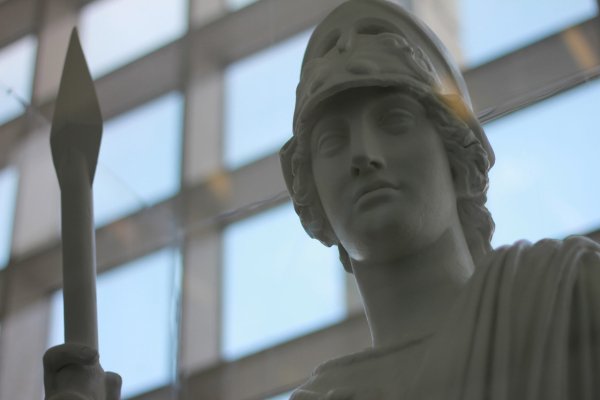 White stone statue of the Roman goddess Minerva, holding a spear, gazing to her left