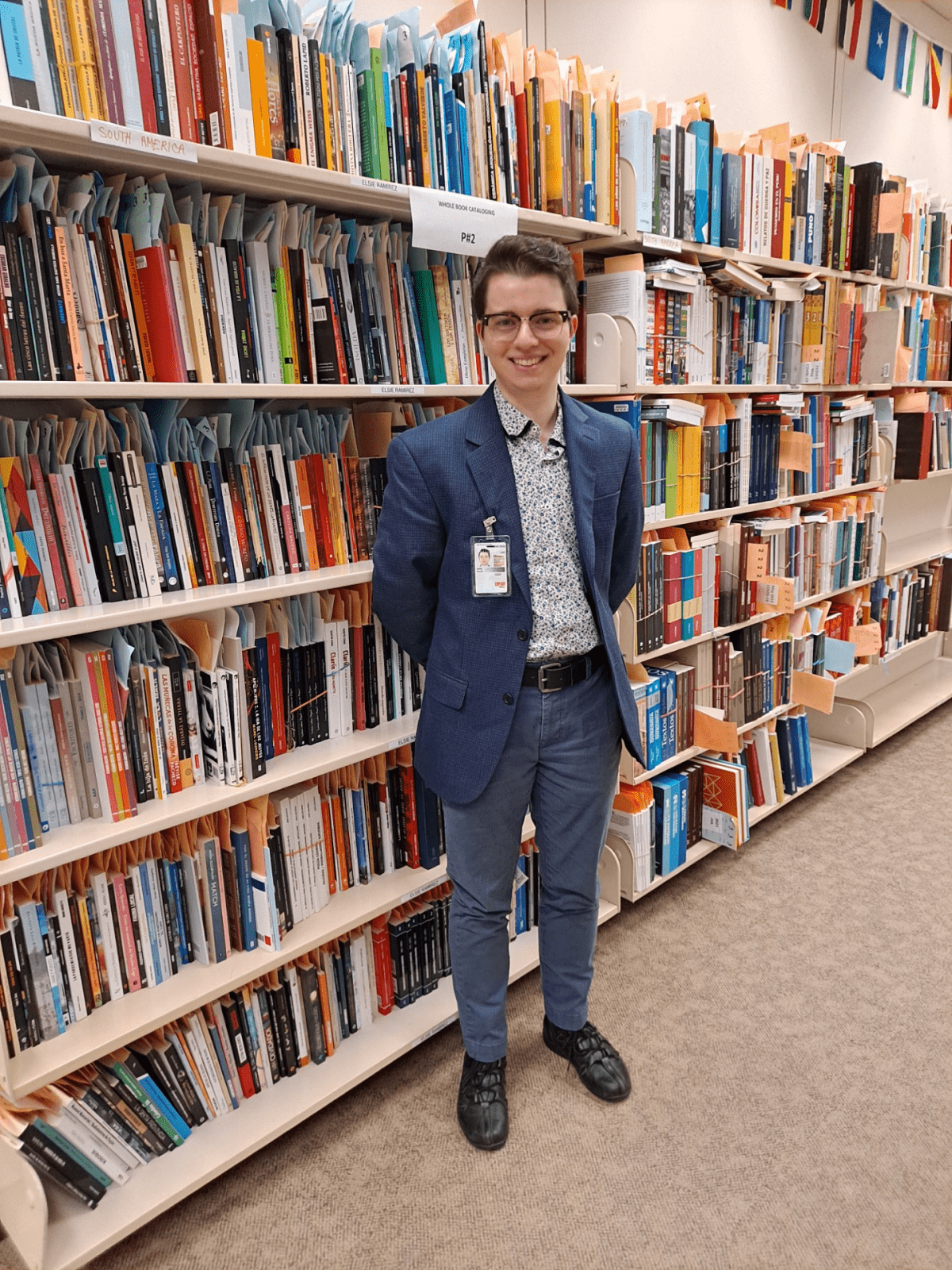Ellis Ging standing in front of a collection of books