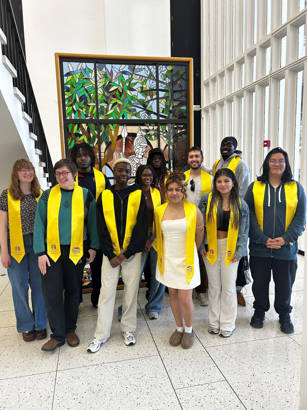 Graduating library student employees wearing gold University Libraries sashes