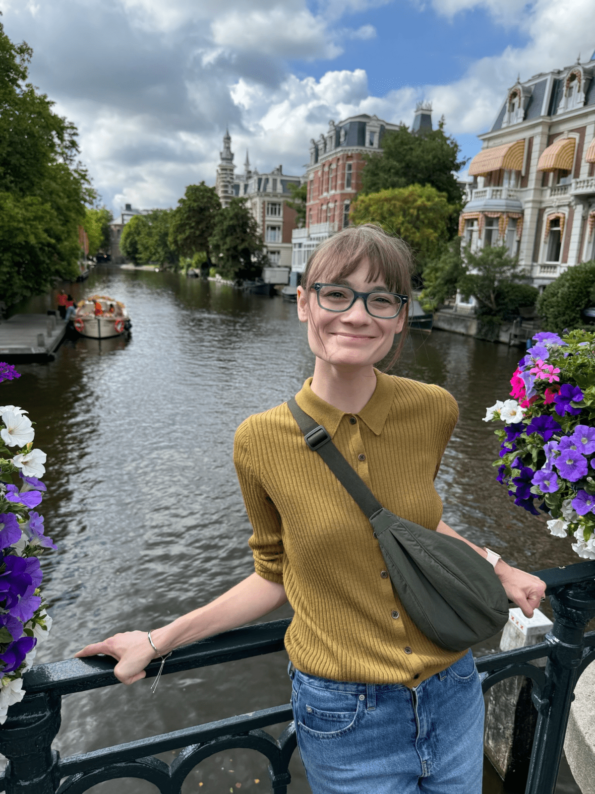 Kaci Wilson posing in front of a river, with European-style homes in the background.