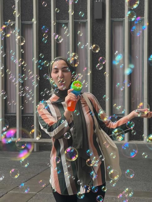 Student blowing bubbles during Stress Less Month