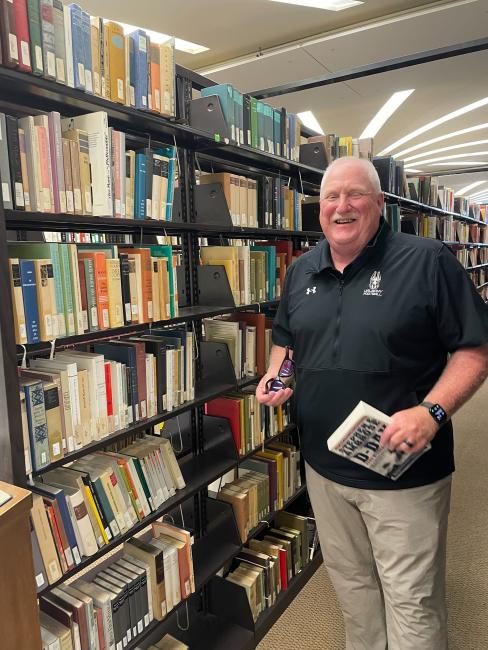 Head Football Coach Greg Gattuso in the University Library's stacks