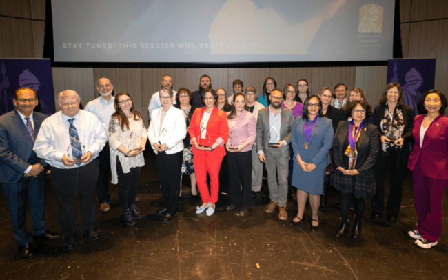 Lauren Puzier poses with President Rodriguez, Provost Kim, and other award winners in the Campus Center Auditorium.